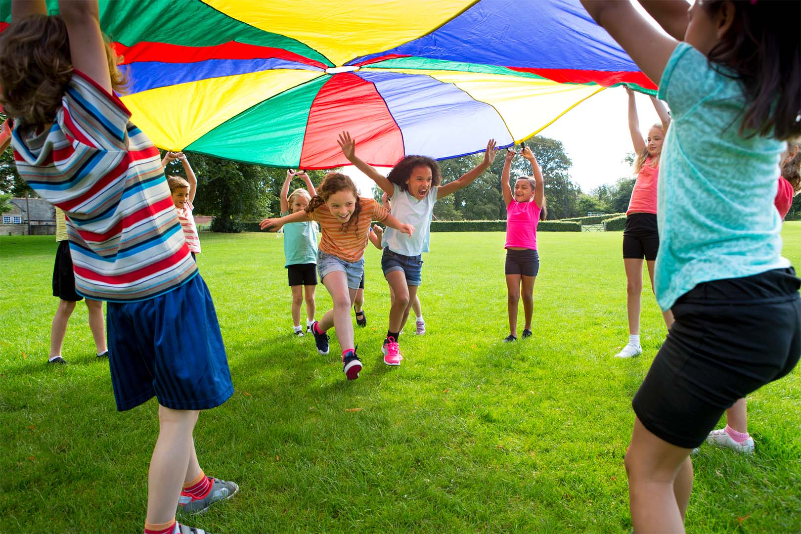 Children playing a game with a colourful parachute.
